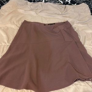 Woman’s mini skirt with bow design. A pastel purple.